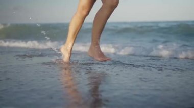 Deniz kıyısında koşan birinin yavaş çekim videosu.