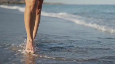 Deniz kıyısında yürürken bacakların ıslandığı yavaş çekim videoları.