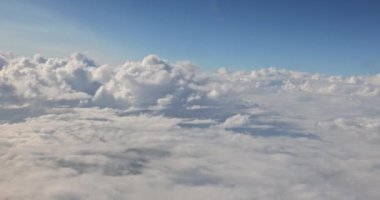 Mavi gökyüzünde bulutlu hava manzarası. Uçak penceresinden güzel doğal manzara..