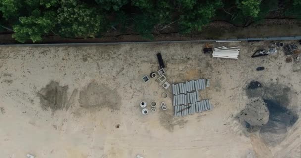 Воздушный панорамный вид строящегося грунта с прокладкой канализационных люков для системы водоснабжения — стоковое видео