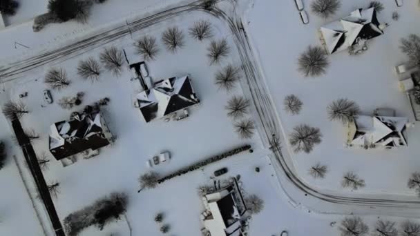 Blizzard pokrývá střechy a asfaltové silnice vedoucí přes klidné předměstí zasněžené ulice a soukromé nemovitosti v idylické vesnici. — Stock video