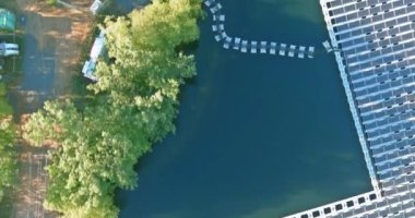 Yenilenebilir enerji eko teknolojisinin hava üst görüntüsü. Elektrik endüstrisi. Gölde yüzen güneş panelleri.