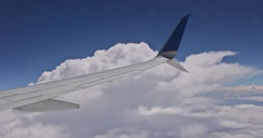 Mavi gökyüzü arka planında, bulutların üstünde uçan uçaklar..