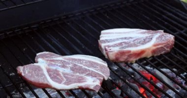 Sulu, çiğ domuz bifteği kızartılmış ateş kömürleri dumanda kızarıyor.