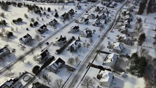Luftaufnahme verschneite Straßen, Privatgrundstücke idyllische Stadt deckt Dächer Asphaltstraßen, die durch ruhige Vororte führen — Stockvideo