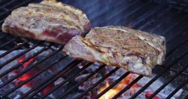 Izgarada pişen lezzetli, sulu etli domuz bifteği.