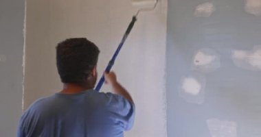 Duvarları astar boyayla boyamak bir evin beyaz renk tamiri üzerine