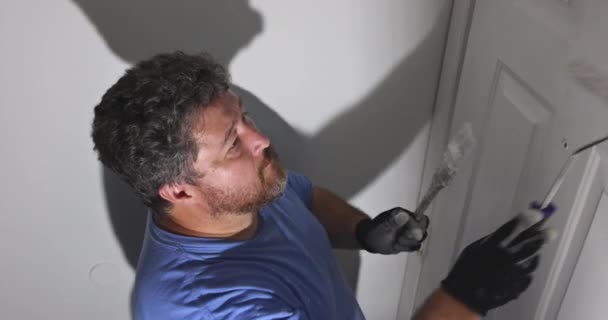 Contratante pintor atualizando cores de portas de pintura moldagem guarnição usando pintura de rolo de mão — Vídeo de Stock