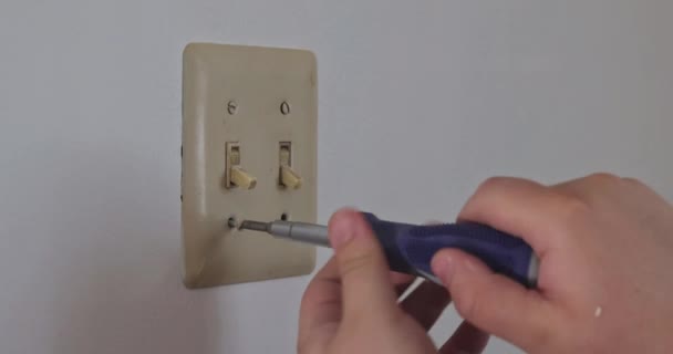 Снятие крышки белого выключателя пластик на стене подготовки к новой стене краски — стоковое видео