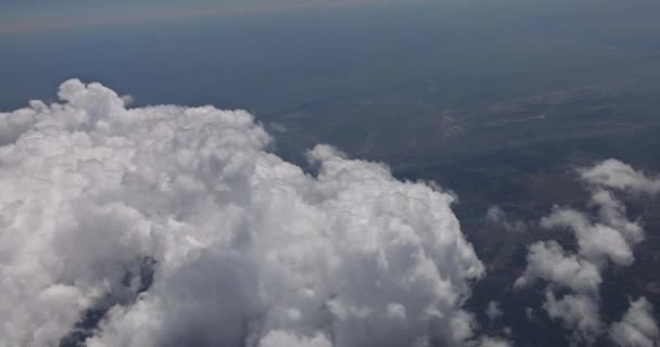 Flygplan flyger ovanför moln i flygplan vinge på blå himmel bakgrund. — Stockvideo