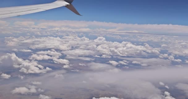 Wing on clouds blue sky with flying view from airplane window — Stock video