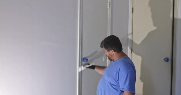 Home renovation in the handyman paints with a paint brush a door frame — Stock Video