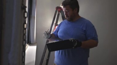 Yeni boya duvarı için hazırlama duvarındaki beyaz ışık düğmesi kapağı plastiği kaldırılıyor