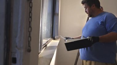 Yeni boya duvarı için hazırlama duvarındaki beyaz ışık düğmesi kapağı plastiği kaldırılıyor