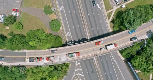 Vista aérea en una carretera que atraviesa una pequeña ciudad con cerca de estacionamiento — Vídeo de stock