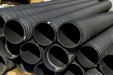 Şehrin kanalizasyon sisteminin yeniden inşası için inşaat sahasında sıra sıra dizilmiş plastik PVC borular