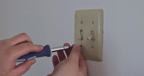 Quitar la tapa del interruptor de pared para enmascarar la salida en preparación para la pintura — Vídeo de stock