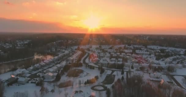 冬の雪の中での空中トップビュータウンハウスの和解はコテージの屋根をカバー. — ストック動画