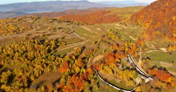 Paesaggio autunnale di campi di villaggio, case e alta montagna con cime è illuminato dai raggi del sole — Video Stock