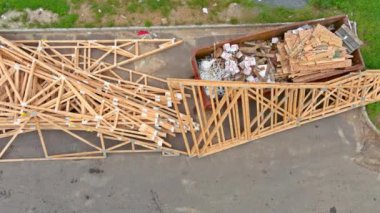 Metal bir konteynırda çöp konteynırları, istiflemeli tahta malzeme tahtaları ve ev yenileme kirişleri..