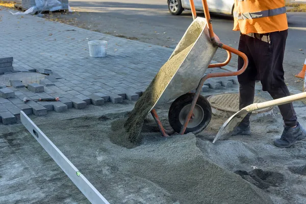 Road construction works with preparation of the surface to establish sidewalk bricks of sandy sand on a street in the city