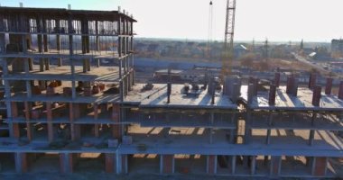 İnşaat vinçleri altında birçok çok katlı bina var.