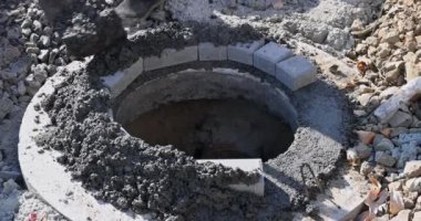 İnşaat işçisi lağım tesisatı. Foseptik tankına kanalizasyon deliği.