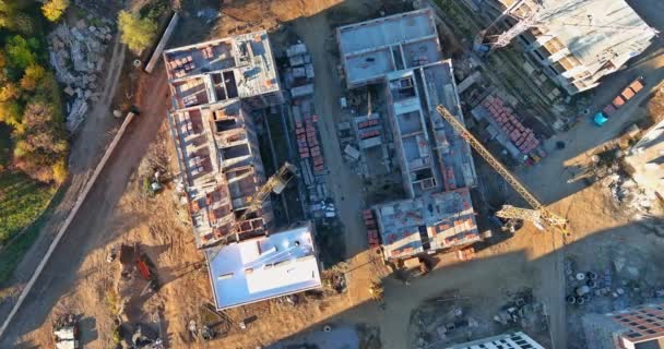 Górny widok z lotu ptaka proces budowy dużego budynku mieszkalnego z dźwigiem — Wideo stockowe