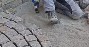 Granit taşlı asfalt döşeme, kaldırım döşeme için endüstriyel kaldırım taşları kullanan işçiler.
