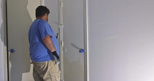 Contractor painter updating colors of painting doors molding trim using hand roller painting — Stock Video