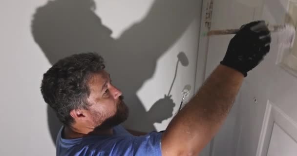 Рука рабочего с перчатками в покраске дверной отделкой — стоковое видео