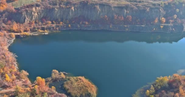 Uma lagoa de pedreira formada durante a pedra de mineração com plantas verdes cobertas com água turquesa clara — Vídeo de Stock