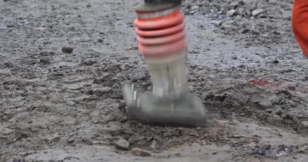 Herramienta eléctrica de martillo vibratorio en el suelo en los trabajos de construcción en la instalación de aceras de pavimento — Vídeo de stock