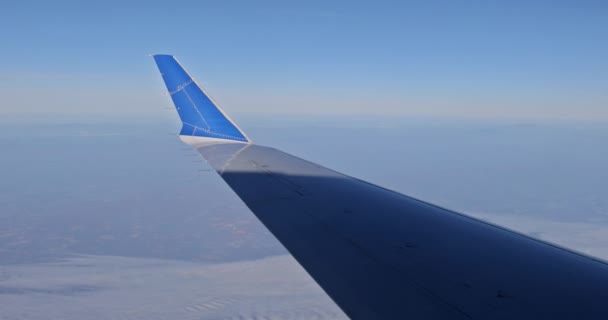 Felhők és ég, ahogy egy repülő repülőgép szárnyán látható — Stock videók