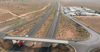 ABD 'de eyaletler arası çöl yolu yakınlarındaki otoyol altyapısı için büyük araba ve kamyonların hava manzarası.