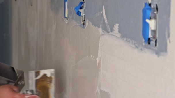 Construction worker with trowel plastering a wall at apartmen room — 图库视频影像