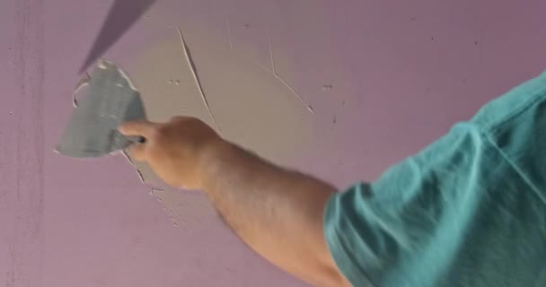 Hand van de werknemer pleisterwerk afwerking stopverf spatel aan muur voor kamer — Stockvideo