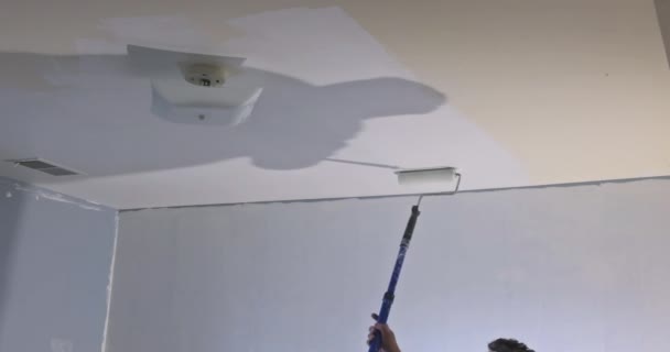 Primer plano del pintor en pintura blanca un techo con rodillo de pintura — Vídeos de Stock