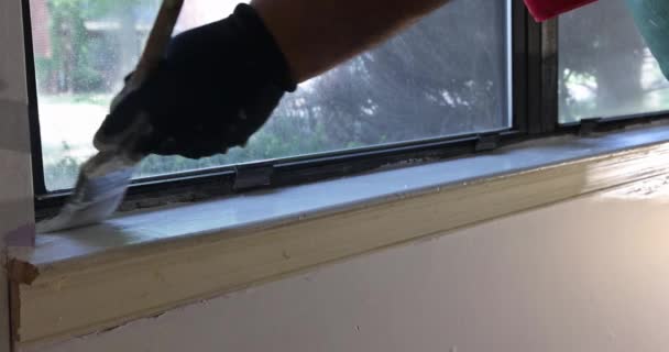 Close up of paintbrush hand painting window sills with white paint — Stock Video