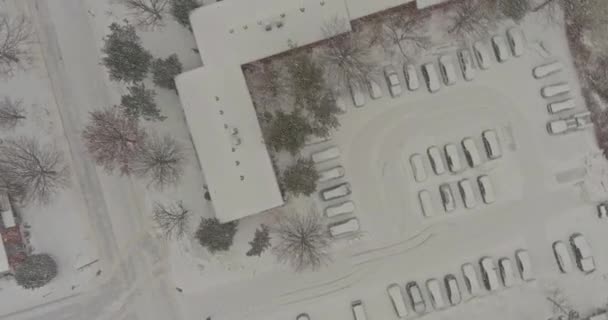 Luftaufnahme schneebedeckte Dächer von Ferienhäusern Reihenhaussiedlung im Winter Schneefall in Schneeflocken — Stockvideo