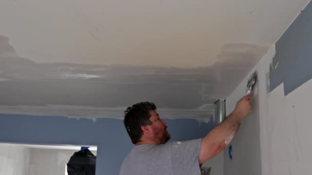 Werknemer troffels plamuur het plafond op gipsplaten met afwerking stopverf hand — Stockvideo