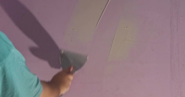 Plâtrier lissant surface murale avec couteau à mastic à la maison — Video