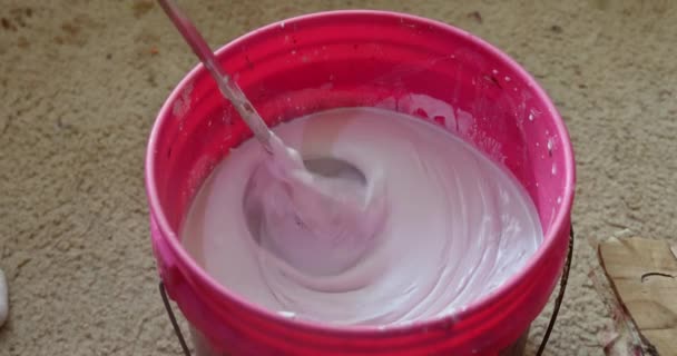 Close up of a builder mixing mortar in a bucket on a construction site — Video Stock