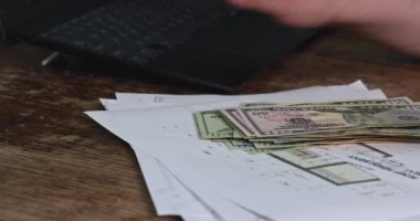 Serbest meslek sahibi iş adamı, elinde dolar banknotları olan nakit gelirleri sayıyor.
