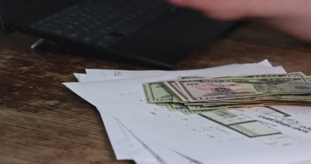 Önálló vállalkozó számolja a készpénz jövedelem tartó dollár bankjegyek asztalnál laptoppal — Stock videók