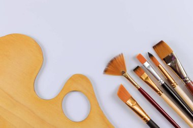 Beyaz izole arkaplanda bir tablo fırçası olan ahşap sanat paleti