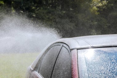 Yüksek basınçlı oto yıkama servisi arabasını yıkarken.
