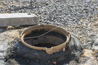 Kanalizasyon inşaatı ve kanalizasyon kuyusu döşeyen elektrik işçisi.