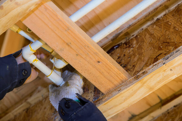 The worker is using a glue PVC pipe for installing the water pipe in the new house