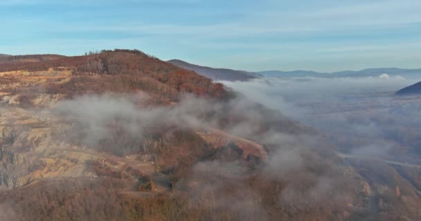 Niebla en árboles del bosque otoñal temprano en la mañana hermosa vista del valle sobre la montaña cerca de la cantera de la mina de piedra — Vídeo de stock